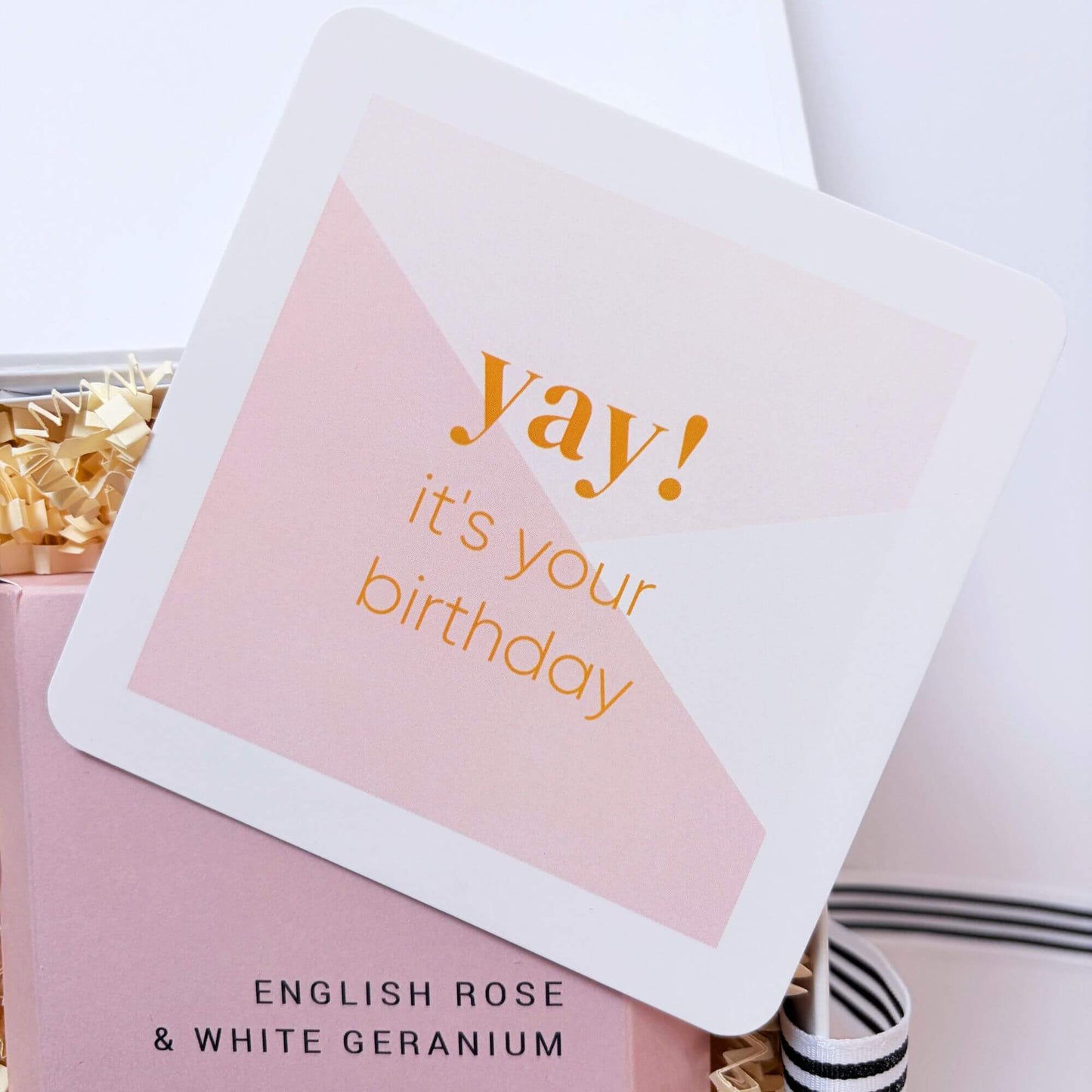 Pink birthday note card placed inside a luxury birthday gift box with rose and geranium bath infusion.