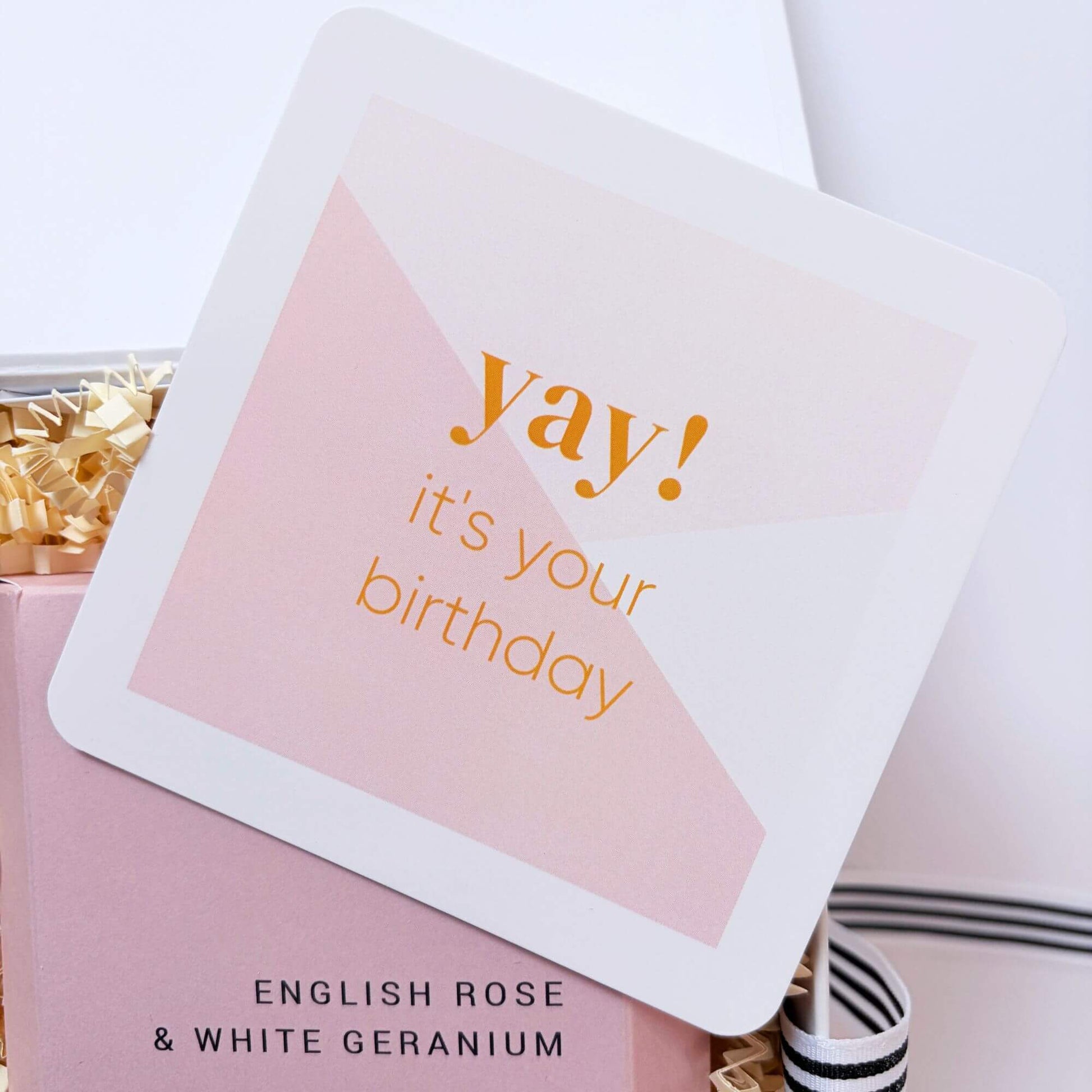 Pink birthday note card placed inside a luxury birthday gift box with rose and geranium bath infusion.