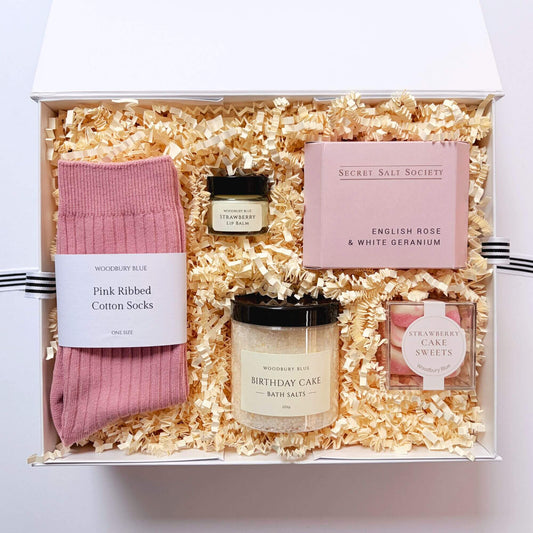 Luxury birthday gift box with pink cotton socks, birthday cake bath salts, strawberry lip balm, strawberry cake sweets and English rose bath infusion