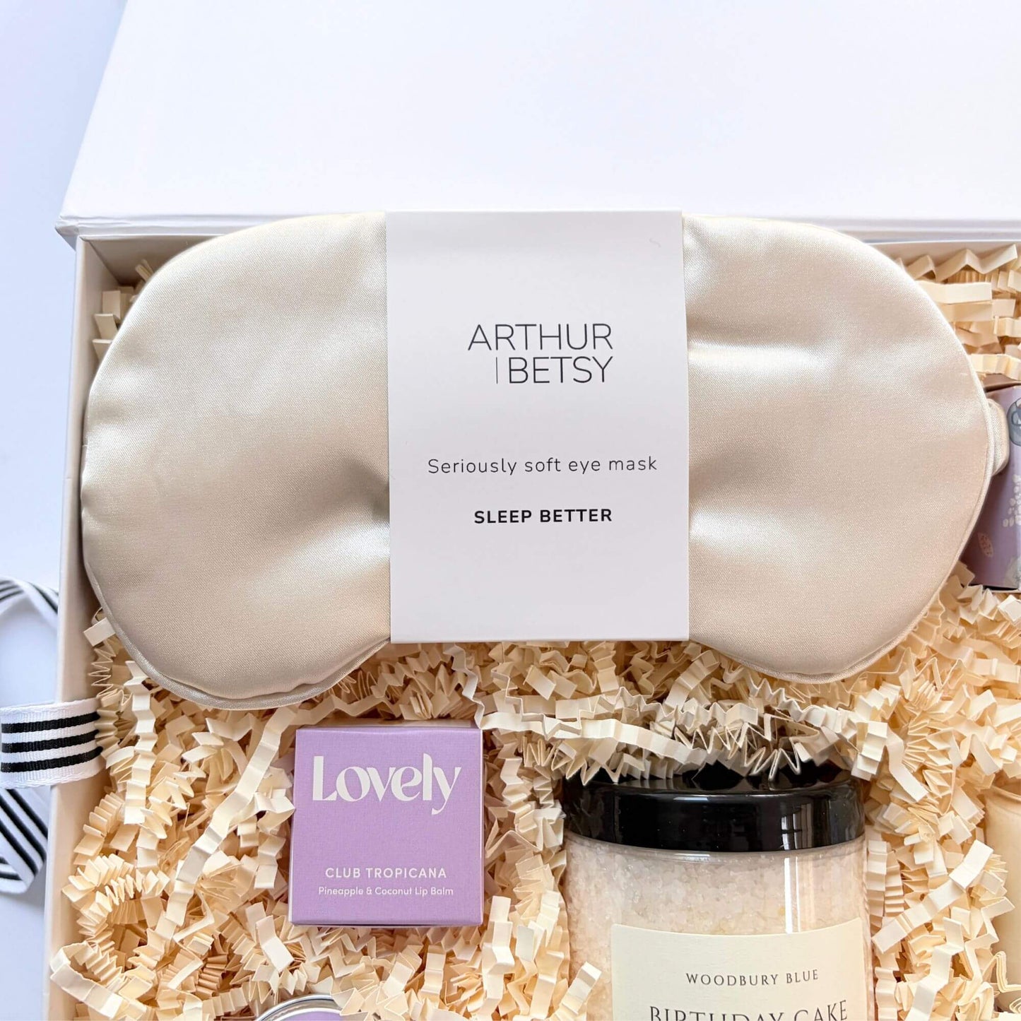 Silk eye mask inside a luxury birthday pamper gift box with bath salts and pineapple coconut lip balm.