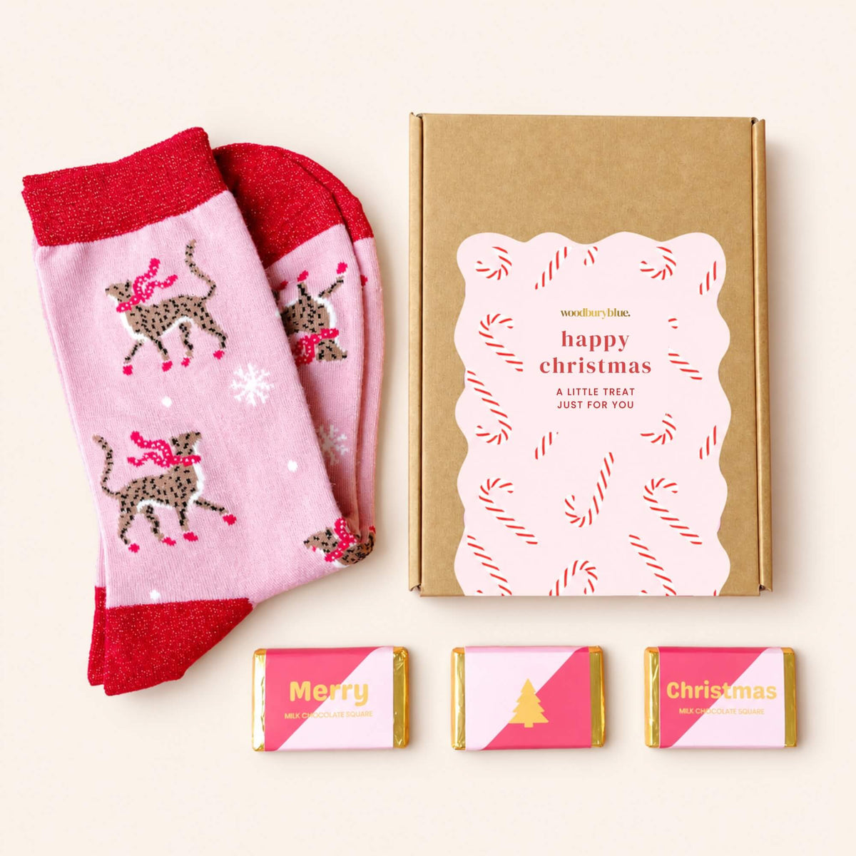 Pink bamboo Christmas socks featuring scarf-wearing cheetahs, displayed with three wrapped milk chocolates and a festive letterbox gift box.