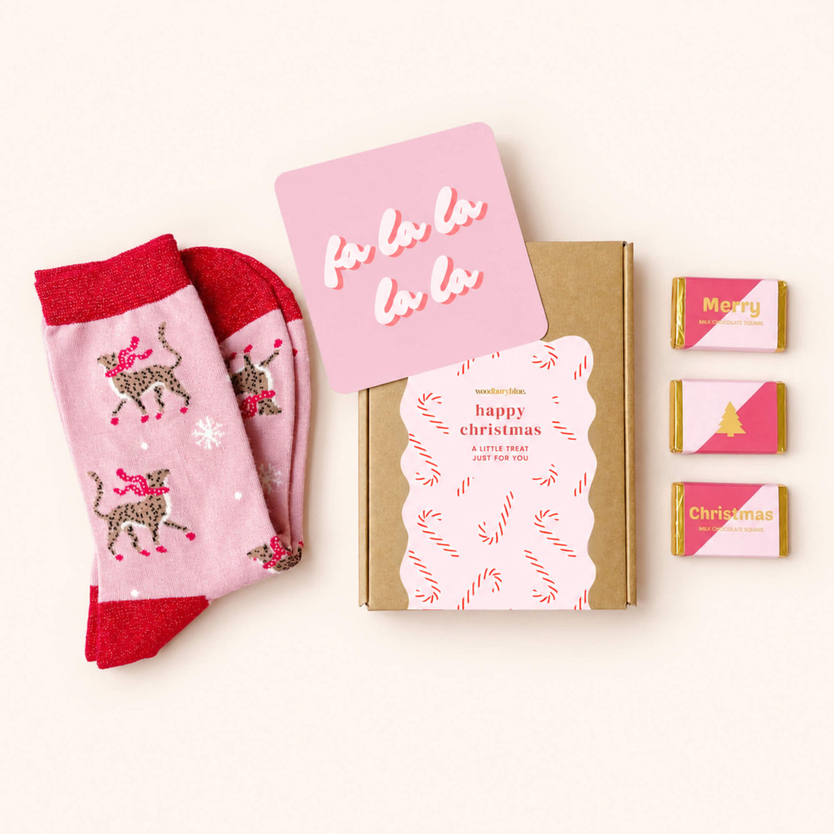 Merry Christmas Socks and Chocs Letterbox Gift with pink cheetah Christmas socks, three milk chocolates, Fa La La notecard and Woodbury Blue gift box.