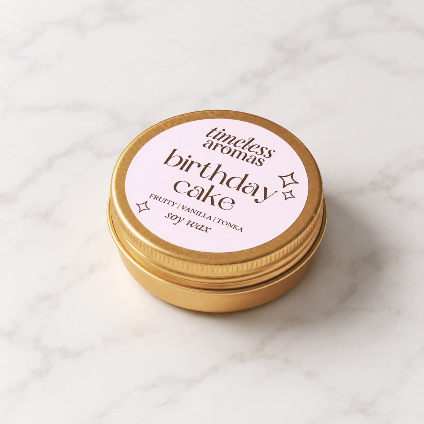 Mini Birthday Cake candle in a gold tin with pale pink Timeless Aromas label