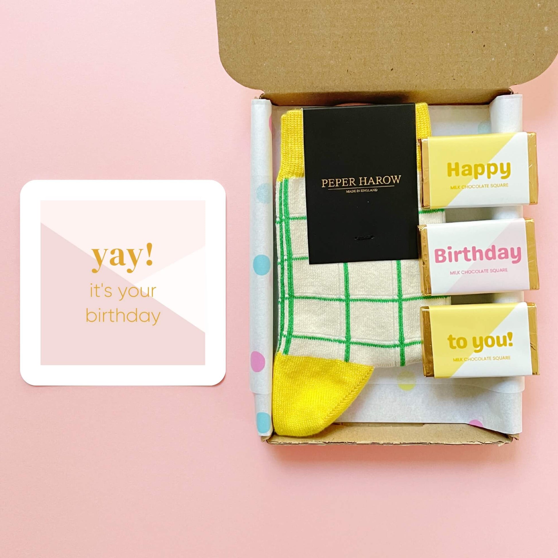 Open birthday letterbox gift showing yellow grid socks, pastel chocolates and yay it’s your birthday card by Woodbury Blue.