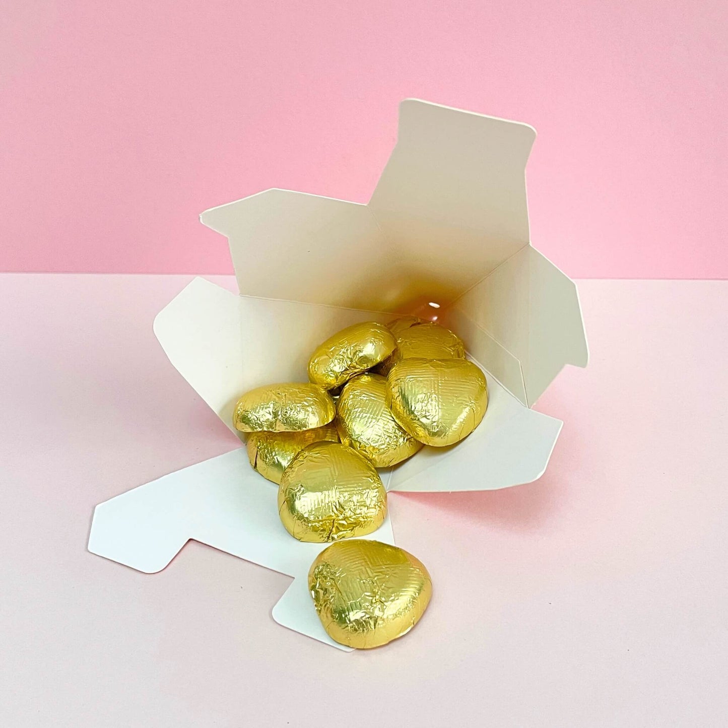 Open gift box filled with gold foiled milk chocolate hearts