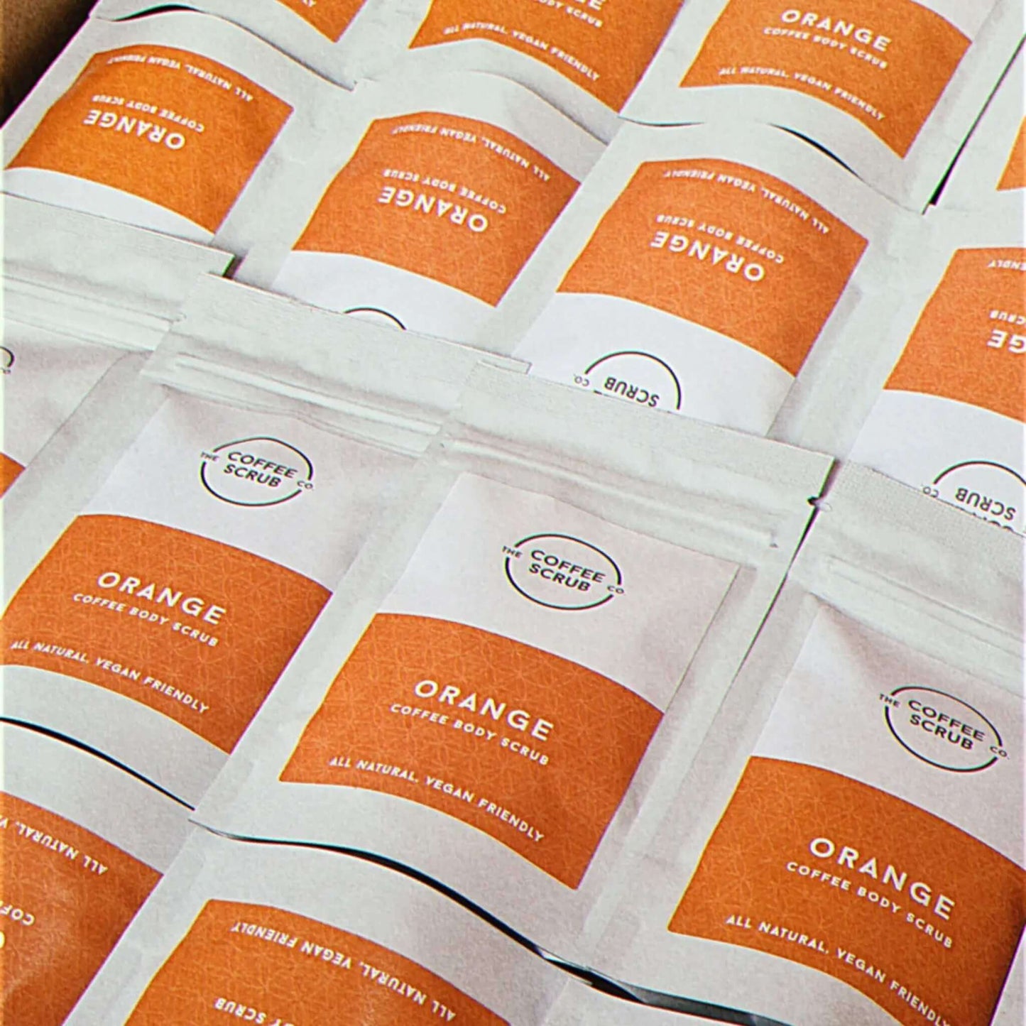 Orange coffee body scrub pouches laid out