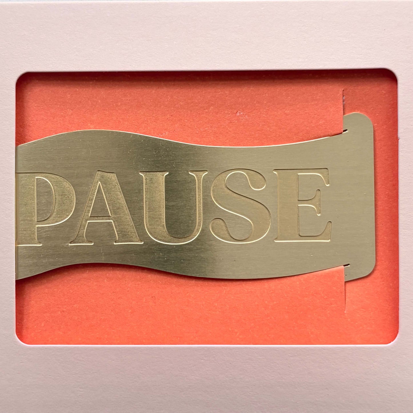 Close-up of the brushed brass Papier 'Pause' Bookmark showing the engraved lettering.