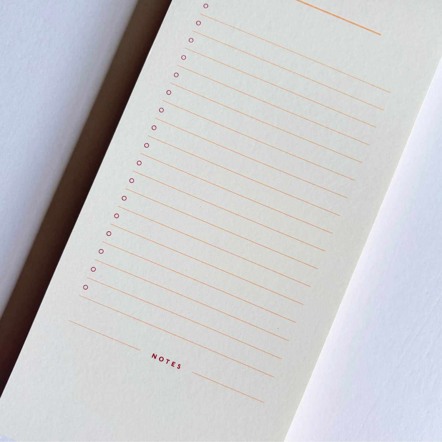 Close-up of the inside of a Papier list notepad with lined sections, check circles and a notes area.