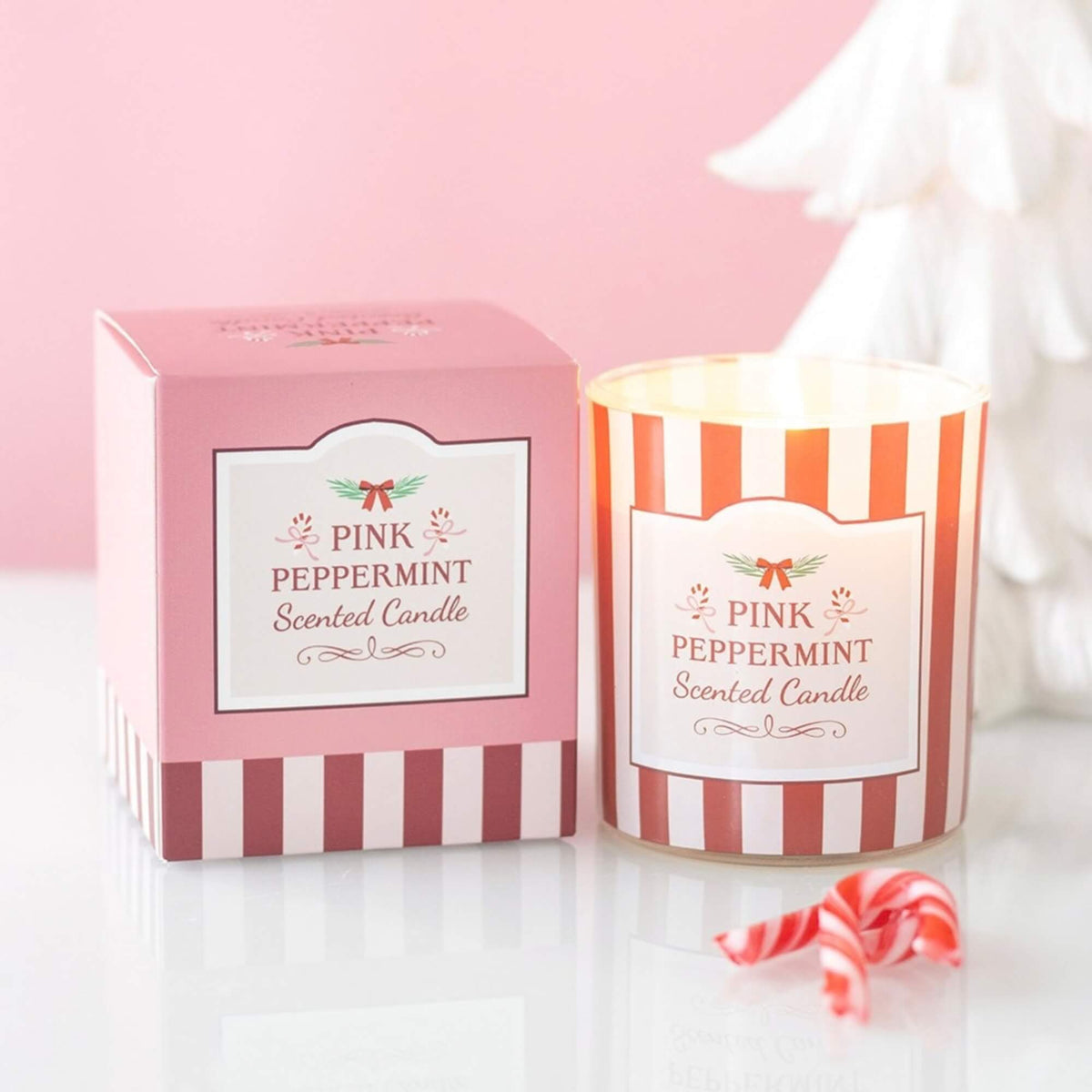 Pink Peppermint scented Christmas candle in red and pink striped glass beside coordinating gift box