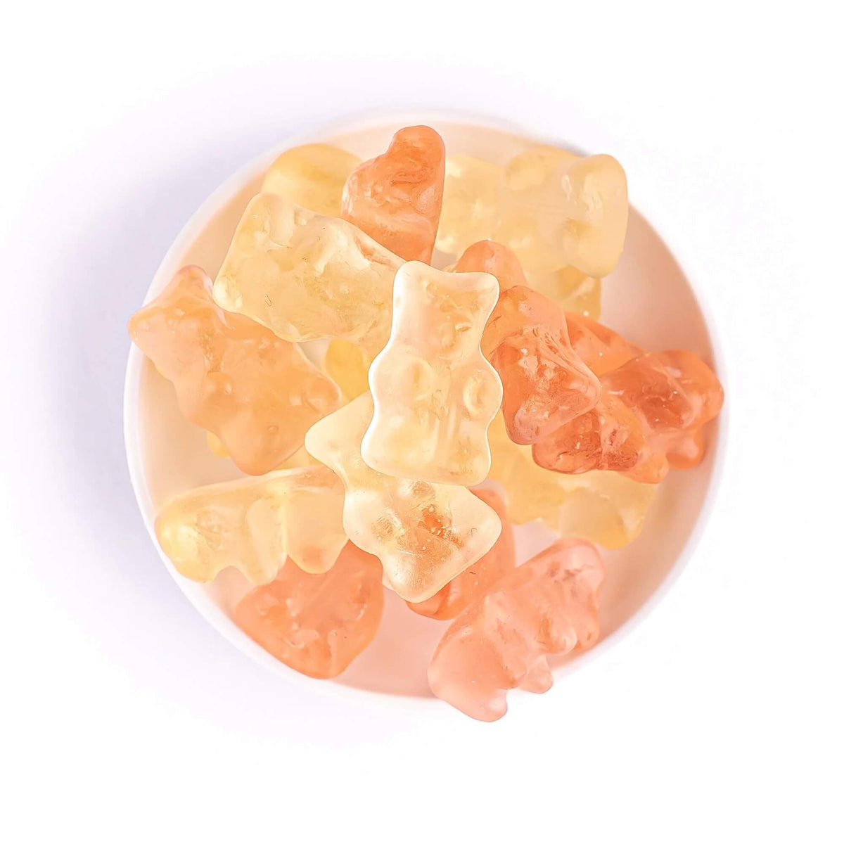 Close-up of yellow and pink Prosecco flavoured gummy bears in a white bowl
