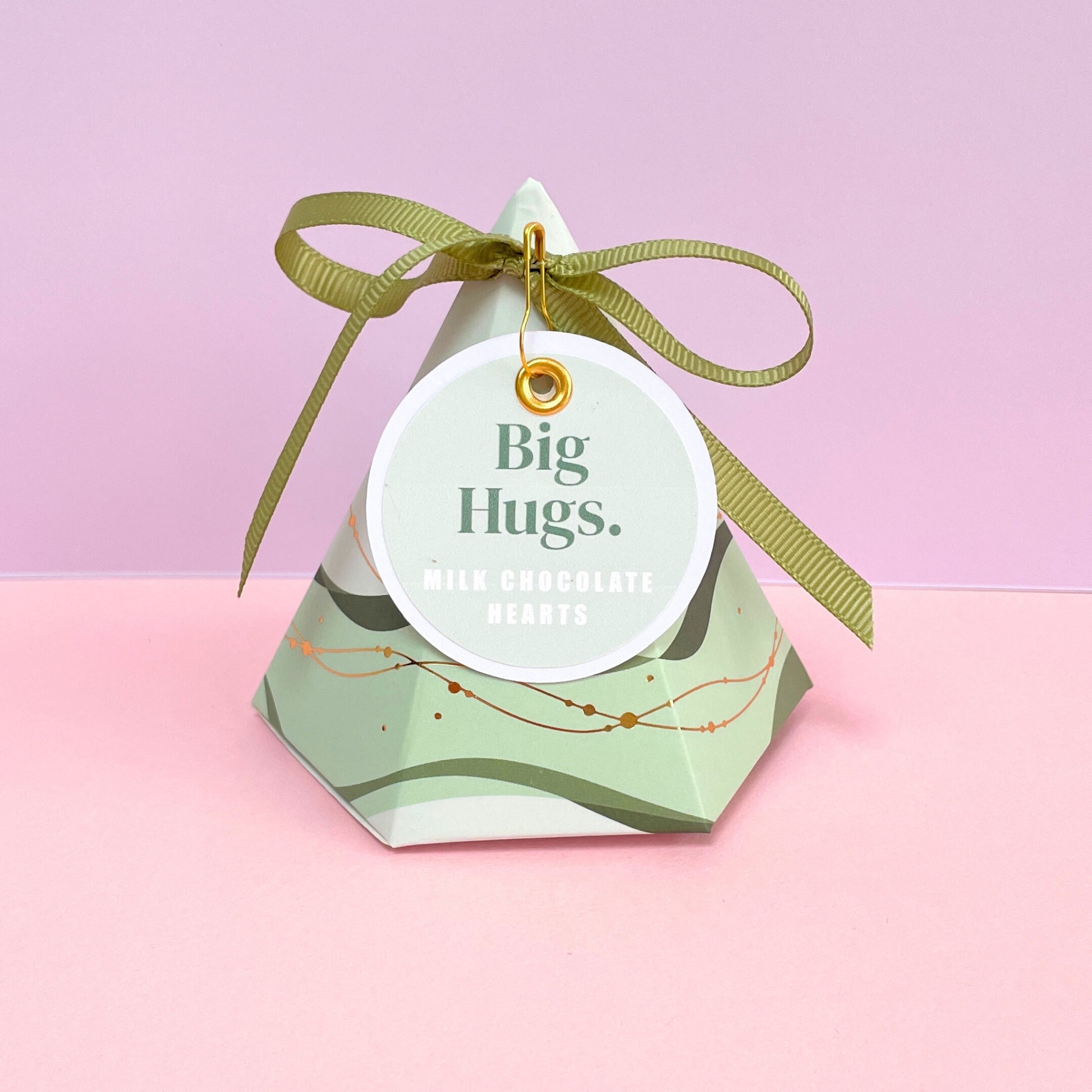 Green pyramid shaped gift box with big hugs gift tag and matching green ribbon