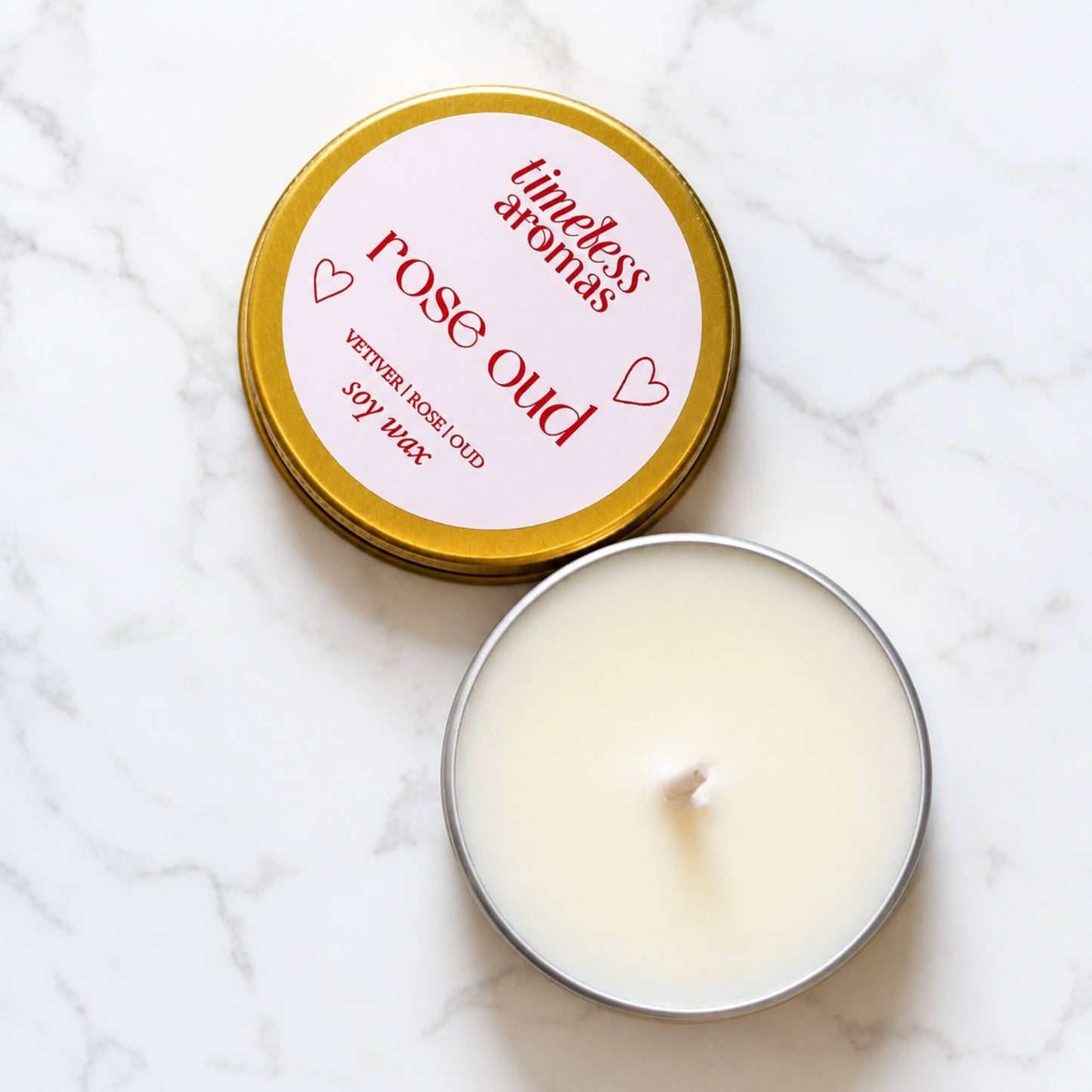 Open Rose Oud soy wax candle in a mini gold tin with labelled lid beside it