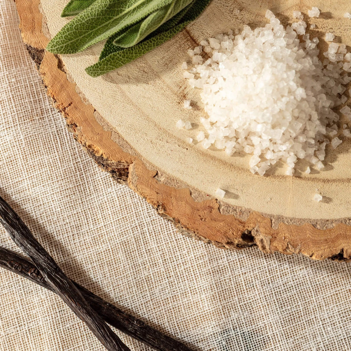 Sage leaves, sea salt crystals and vanilla pods representing the Sage & Sea Salt fragrance