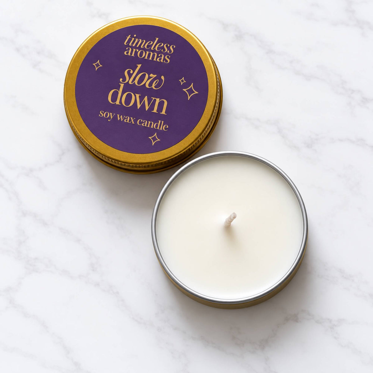 Open Slow Down soy wax candle in a mini gold tin with labelled lid beside it