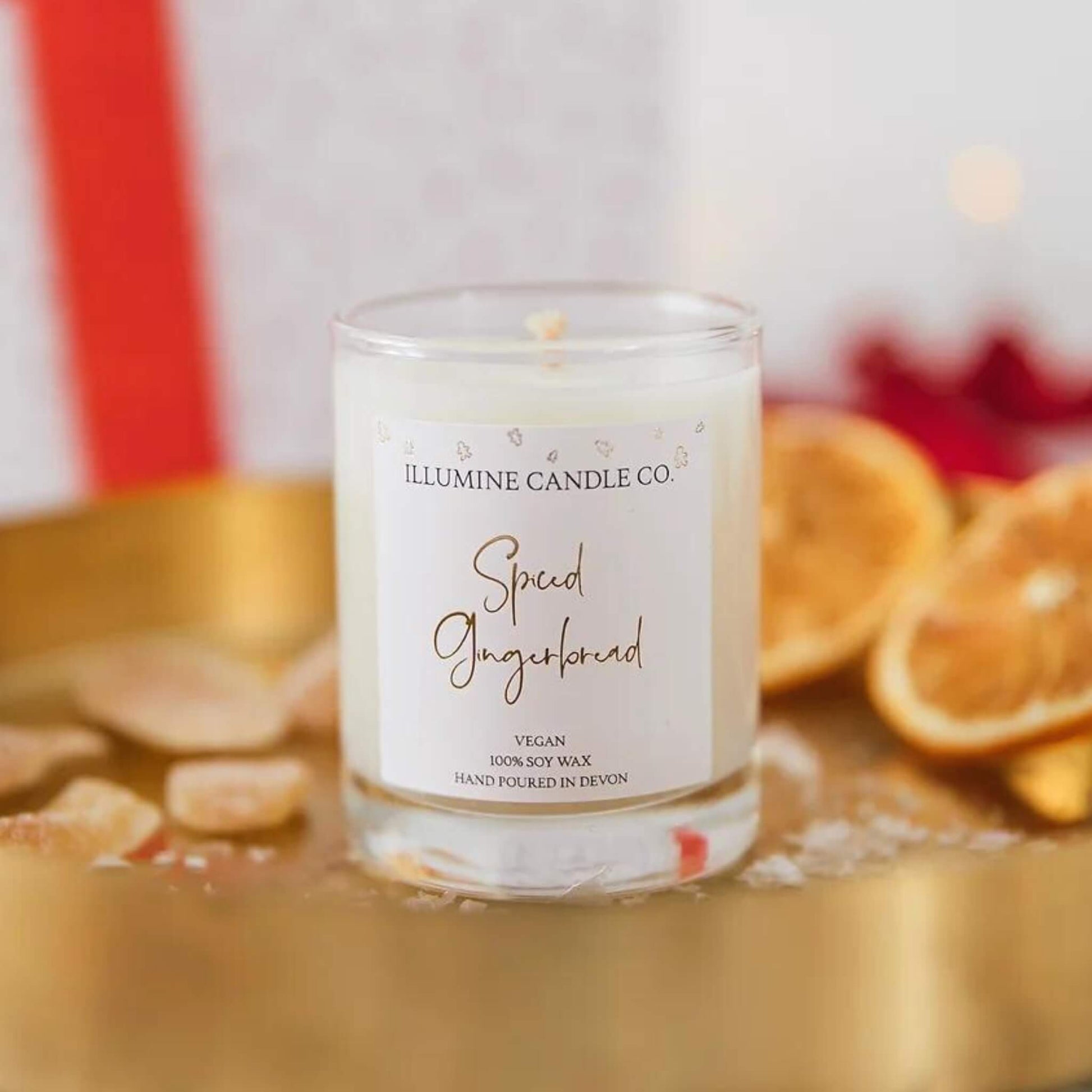 Spiced gingerbread scented soy wax candle in a glass jar with a white label and gold lettering