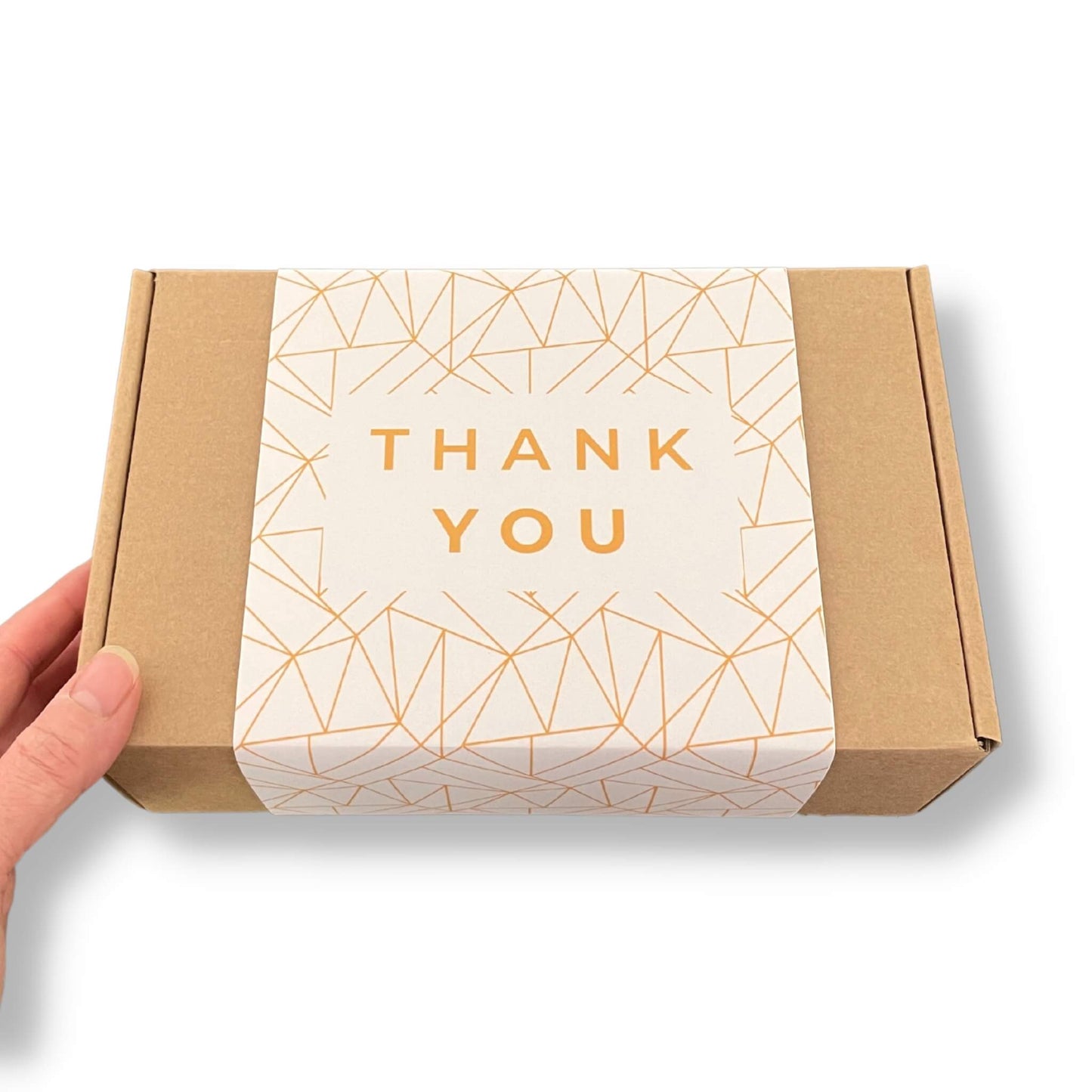 Kraft gift box with a cream sleeve with gold pattern and gold thank you lettering