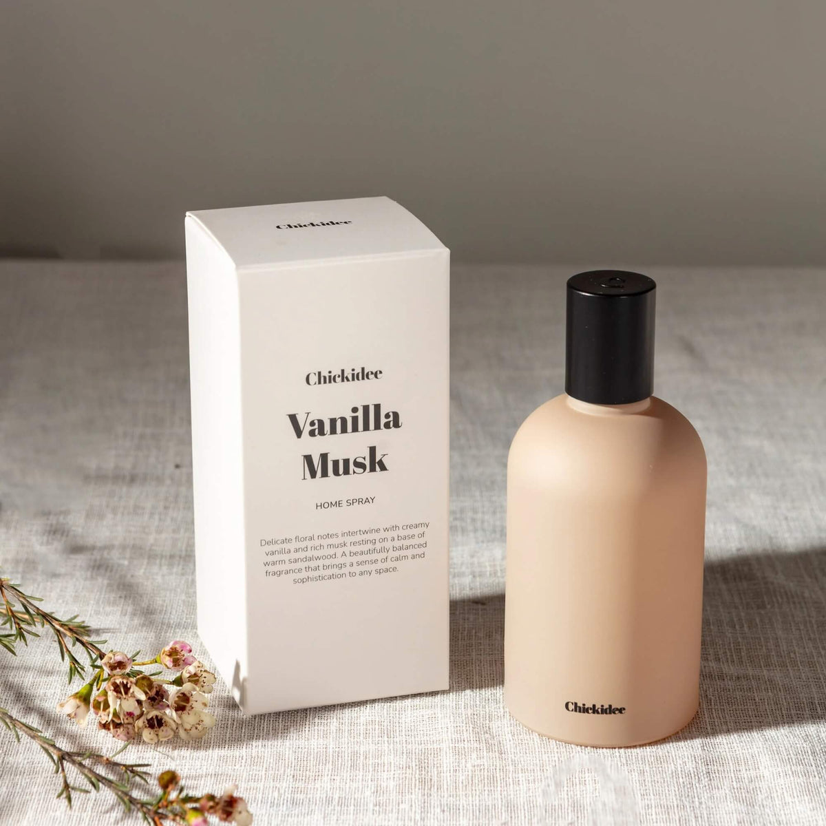 Vanilla Musk room spray and Chickidee box styled on pale fabric with small flowers