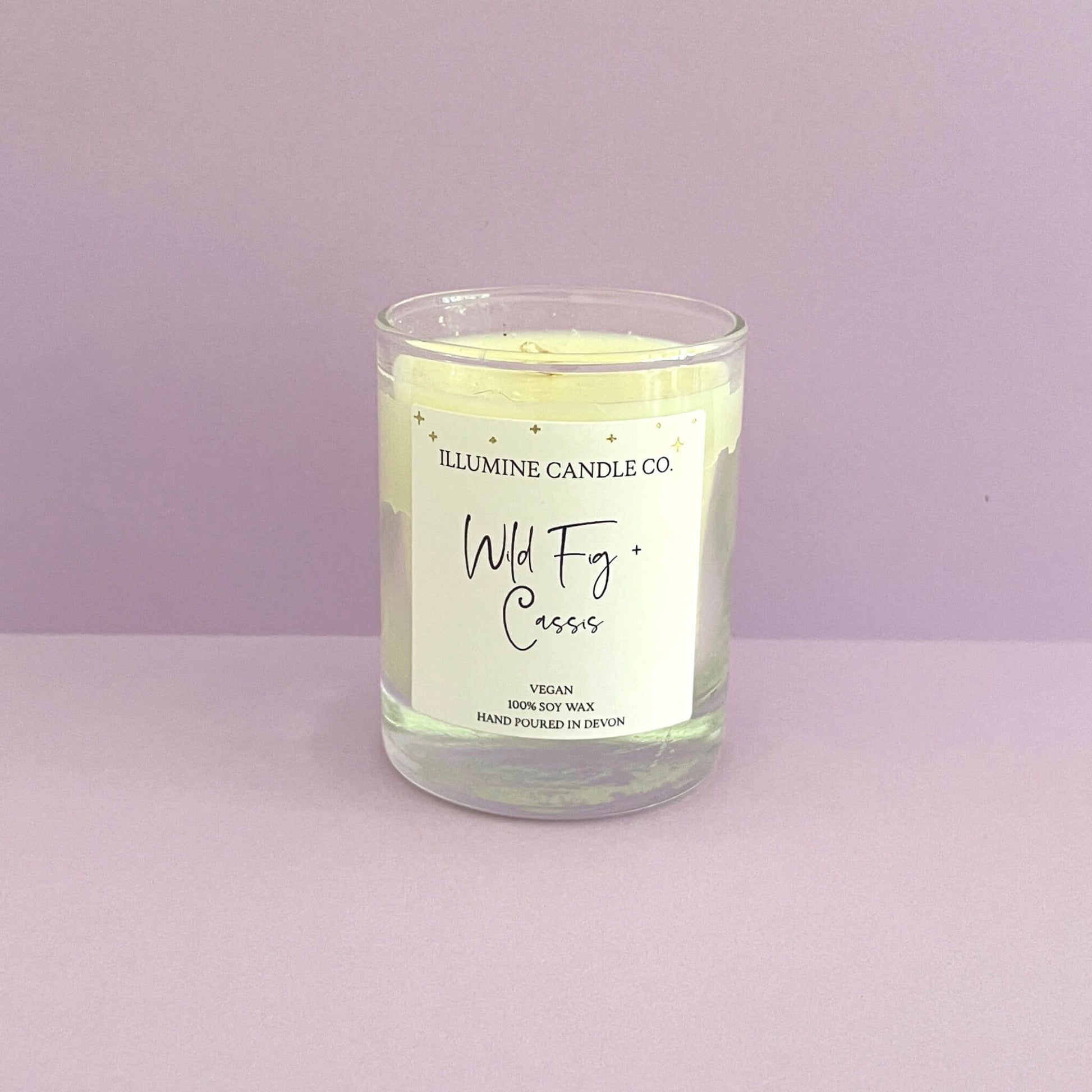 Wild fig and cassis soy wax candle with purple back drop