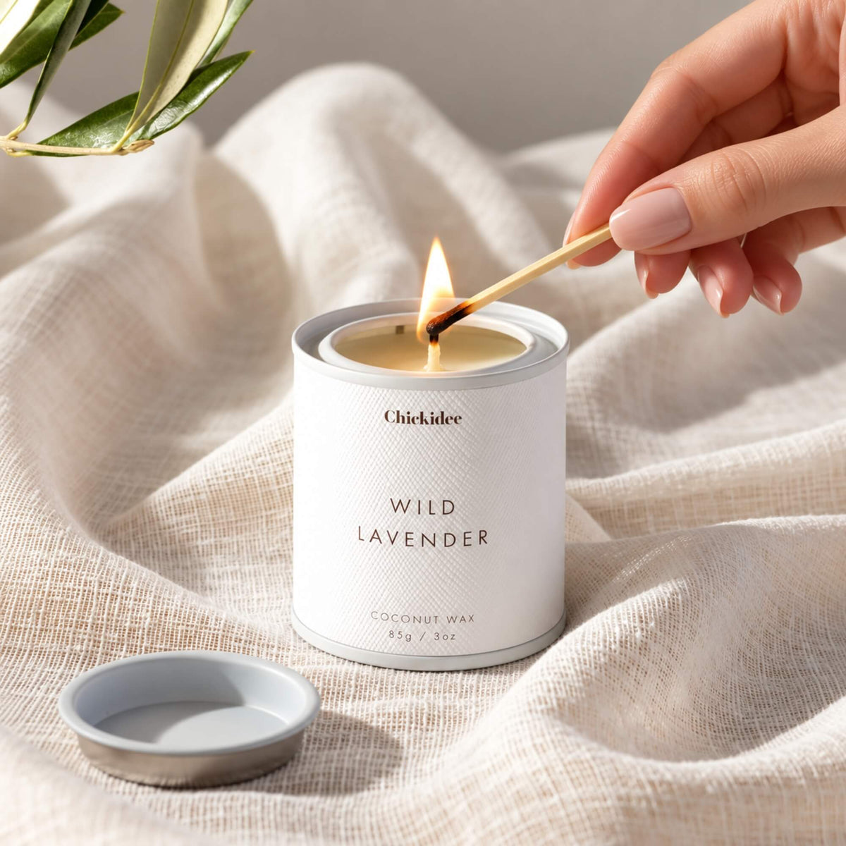Wild Lavender coconut wax tin candle being lit with a match