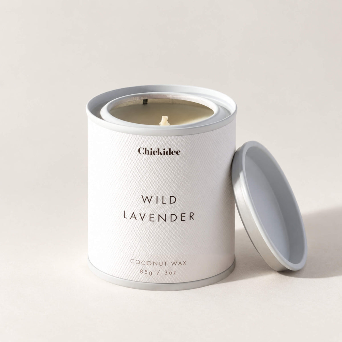 Wild Lavender coconut wax tin candle with removable white lid resting beside it