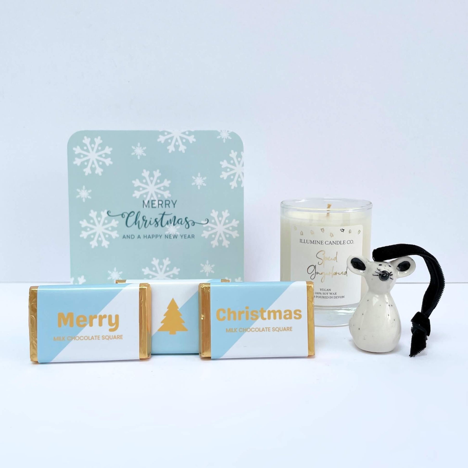 Front view of Winter Glow gift contents: blue snowflake gift box, candle, reindeer, chocolates, and notecard