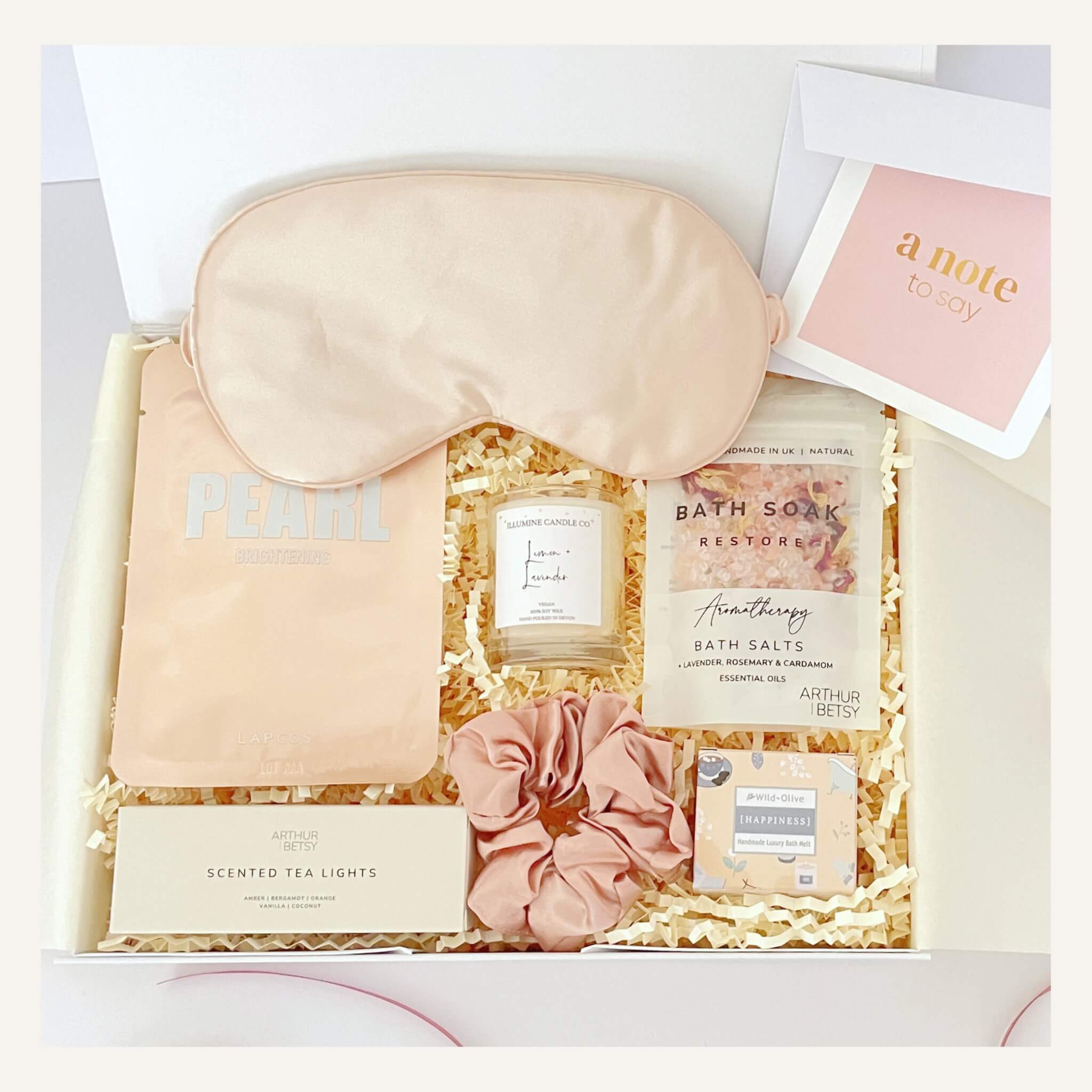 Build your own gift box from Woodbury Blue featuring a silk sleep mask, bath salts, tea lights, scrunchie, and bath melt, with handwritten notecard included.
