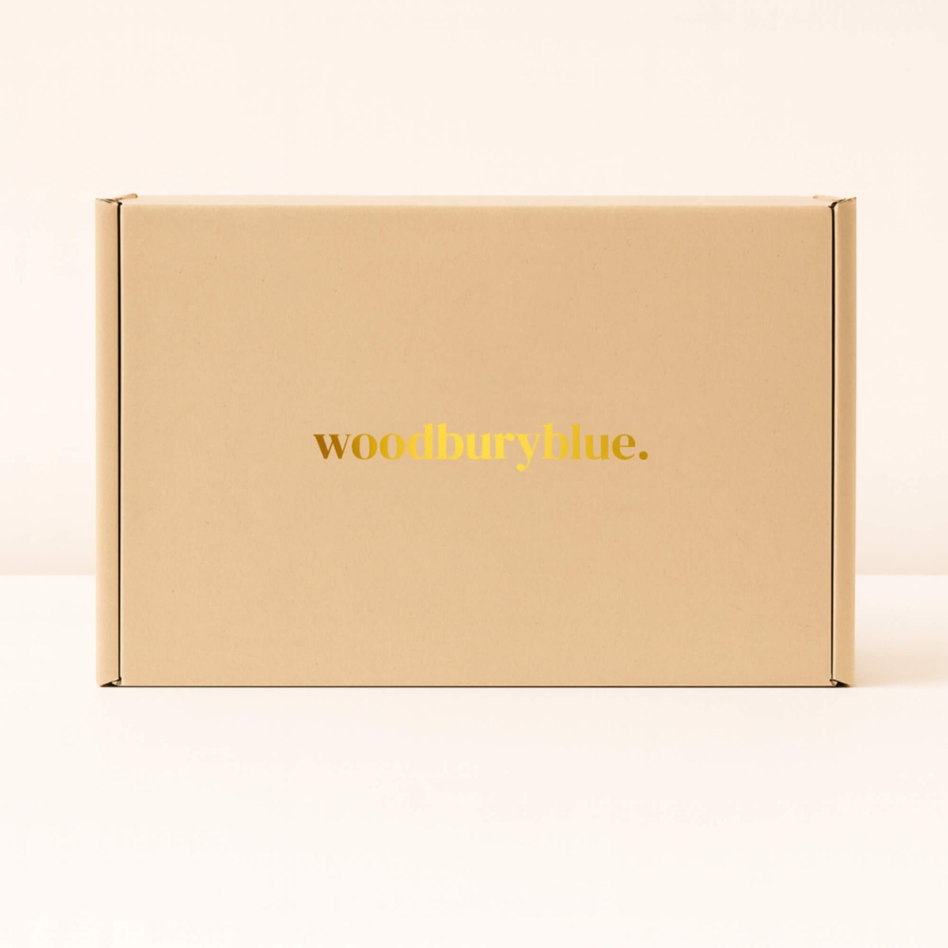 Kraft gift box with simple matt gold Woodbury Blue logo on the front