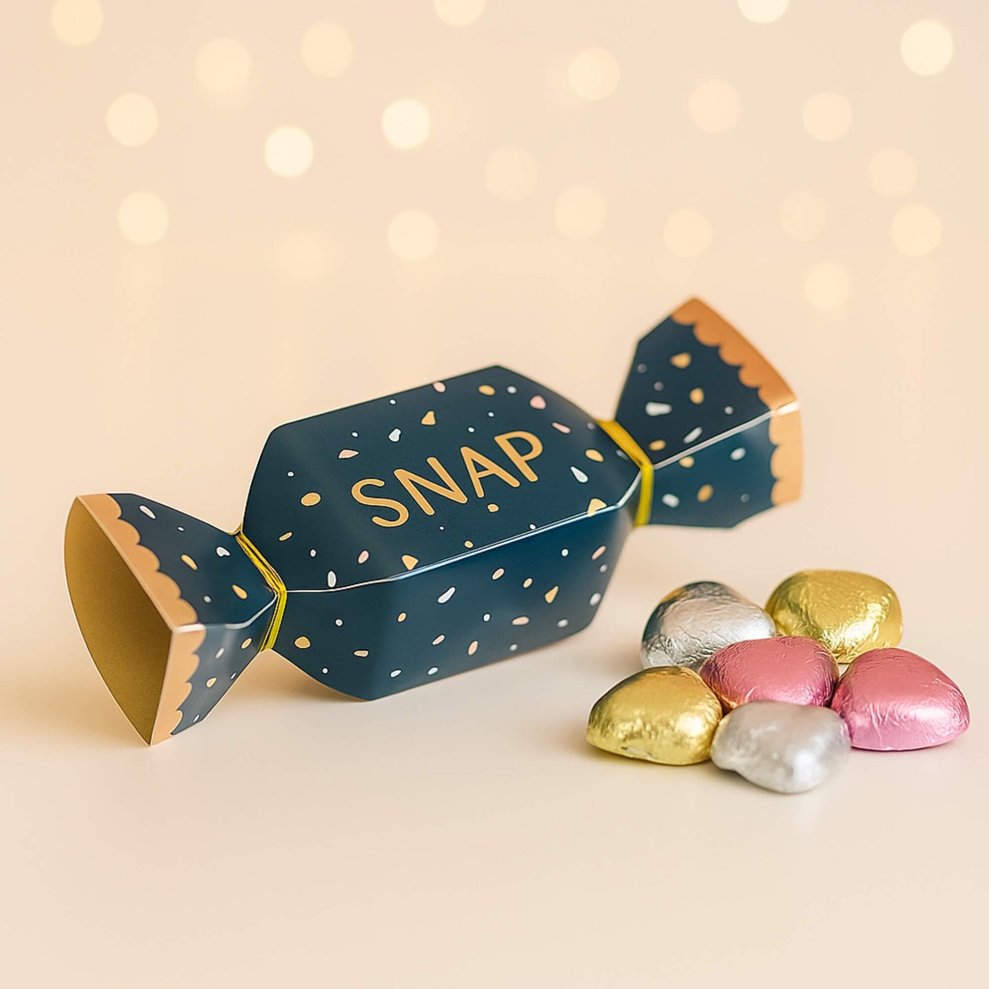 Navy and gold mini Christmas cracker with SNAP design and foil-wrapped milk chocolate hearts by Woodbury Blue, styled on a soft neutral background.
