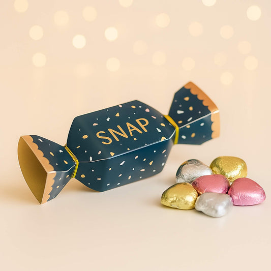 Navy and gold mini Christmas cracker with SNAP design and foil-wrapped milk chocolate hearts by Woodbury Blue, styled on a soft neutral background.