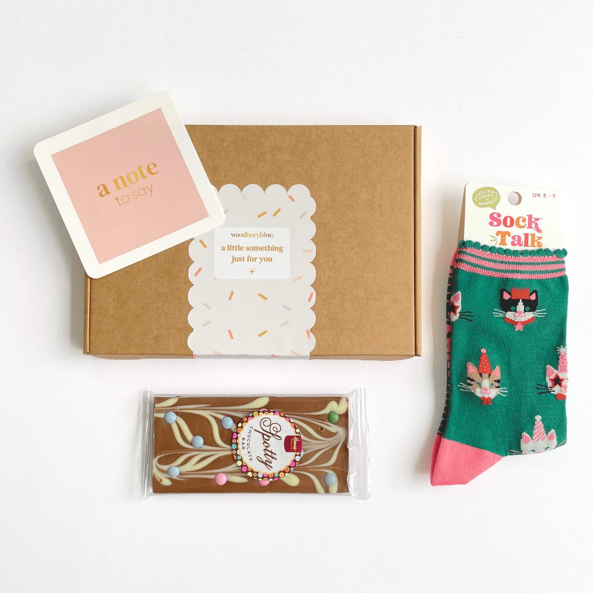 Party Cats Socks and Chocolates Letterbox Gift laid out flat with chocolate bar, pink notecard and gift box