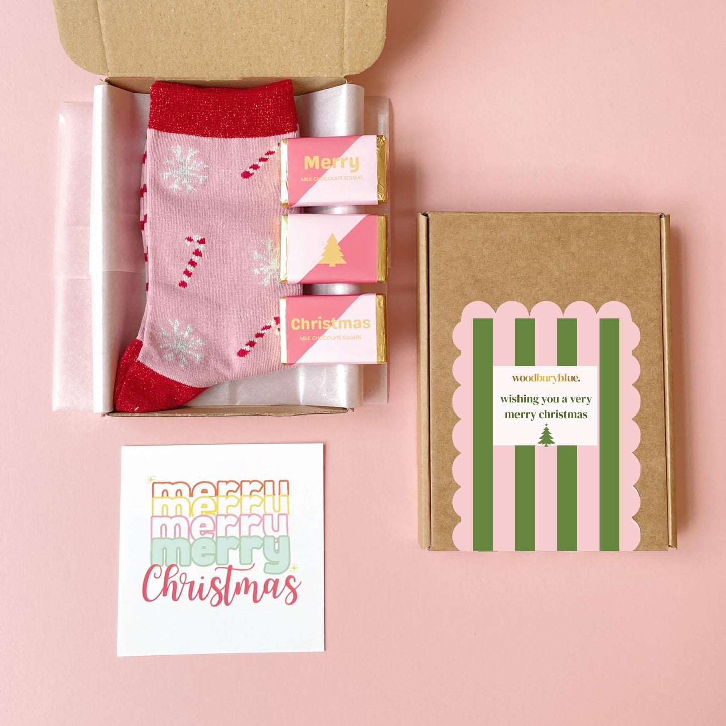 Open flat lay of Woodbury Blue Christmas letterbox gift showing socks, chocolates, and notecard inside kraft box