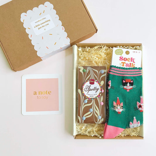 Open Party Cats Socks and Chocolates Letterbox Gift showing chocolate bar, bamboo socks and pink notecard inside kraft gift box